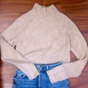 A light beige, fuzzy, long-crop, sweater.